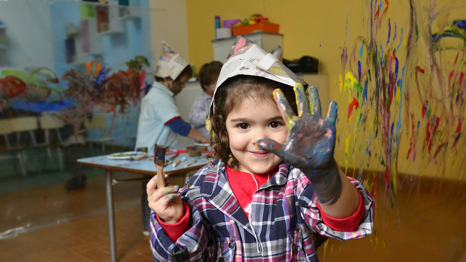 Enfant qui peint joyeusement avec des peintures colorées lors d'un atelier créatif